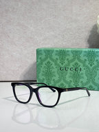 Gucci eyeglasses with black frames, clear lenses, and burgundy temple accents