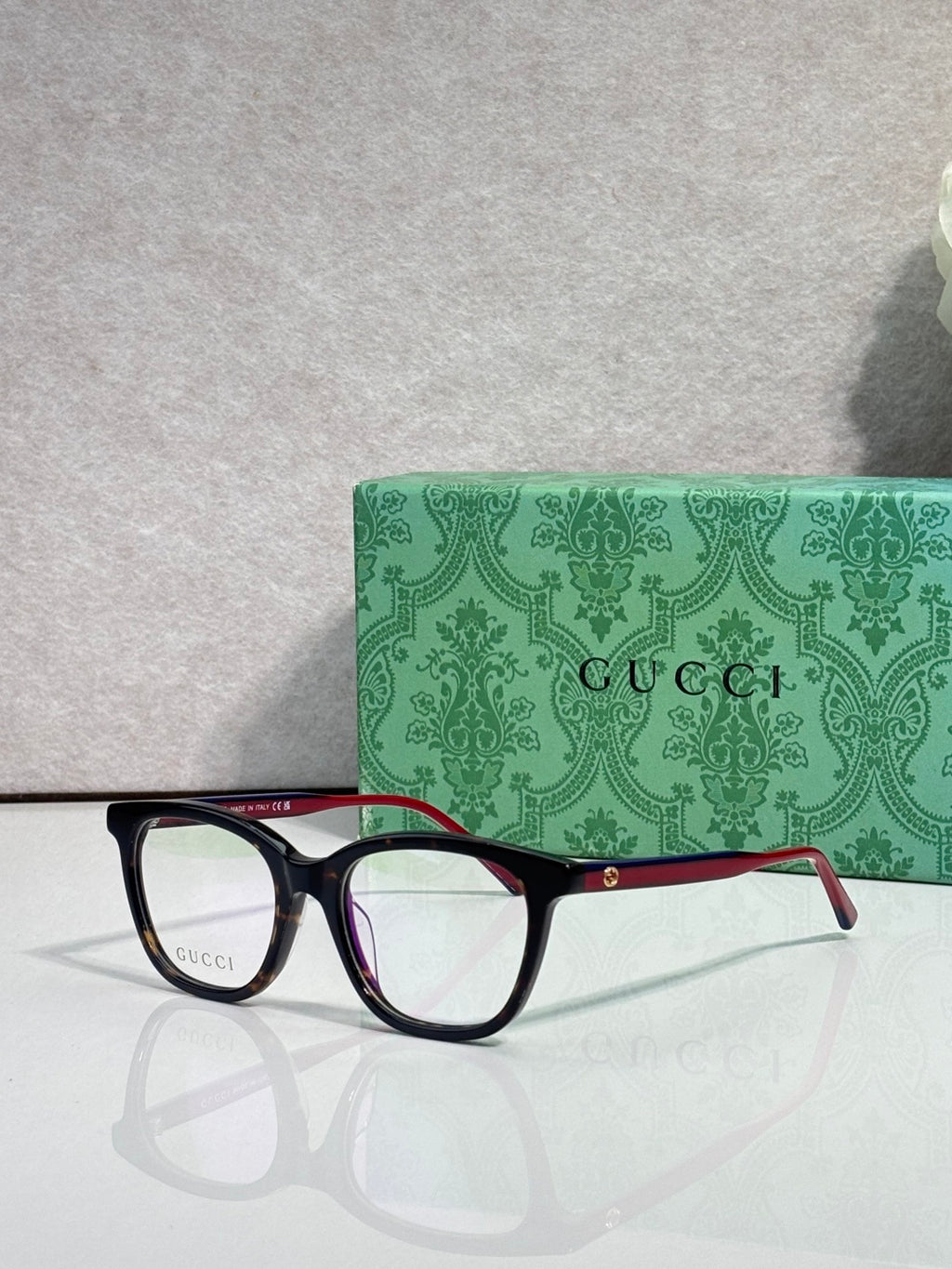 Gucci eyeglasses with black frames, clear lenses, and burgundy temple details