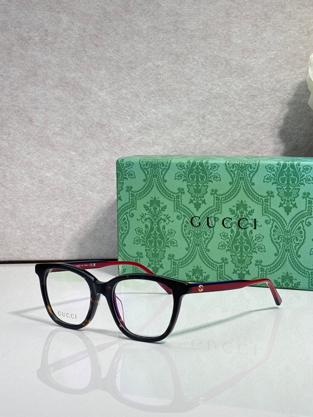 Gucci eyeglasses with black frames, clear lenses, and burgundy temple details