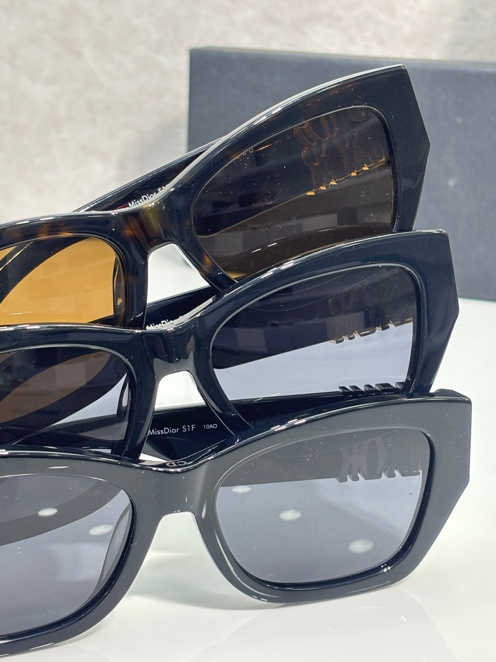 Sunglasses close-up with layered dark frames and amber-brown tinted lenses