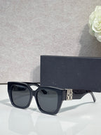Dior sunglasses with black frames and dark gray lenses, gold logo on temple