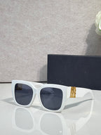 Dior sunglasses with white frames and dark lenses, gold logo detail on the temple