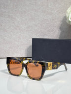 Dior sunglasses with tortoiseshell frames and amber-tinted lenses, gold logo on temple