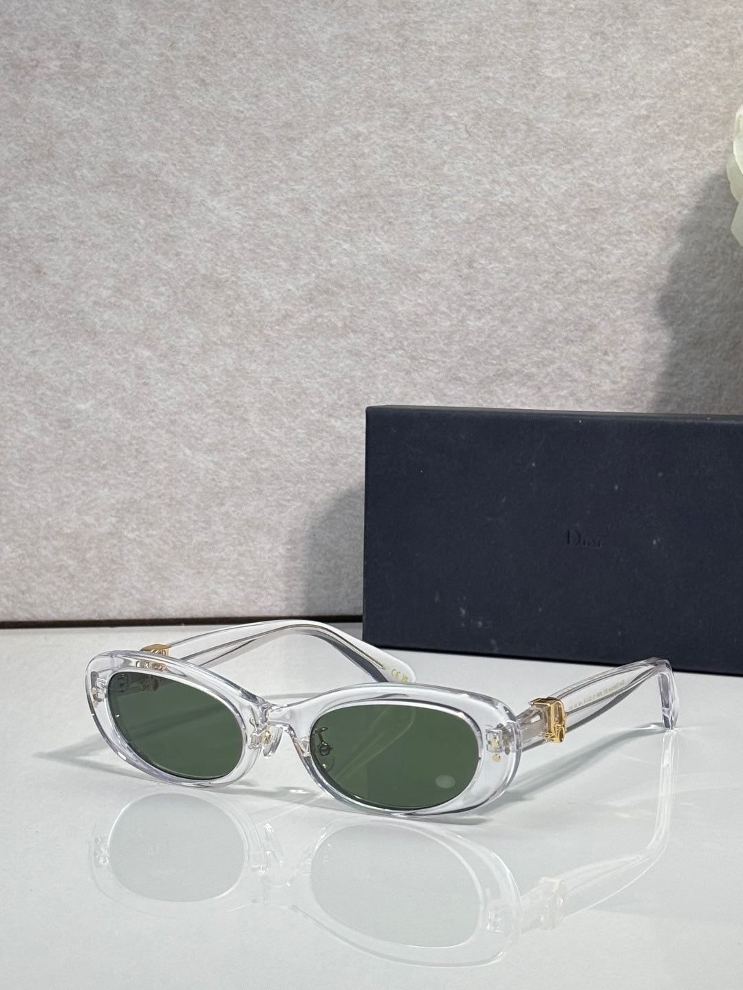 Clear white oval eyeglasses with dark lenses and gold-tone accents