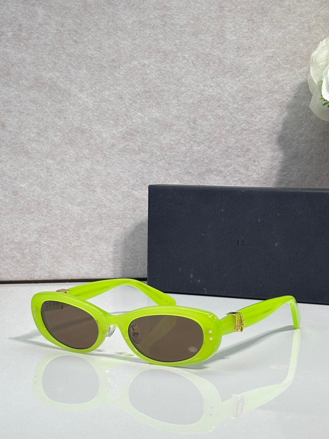 Neon green oval eyeglasses with dark lenses and gold-tone hinge detail