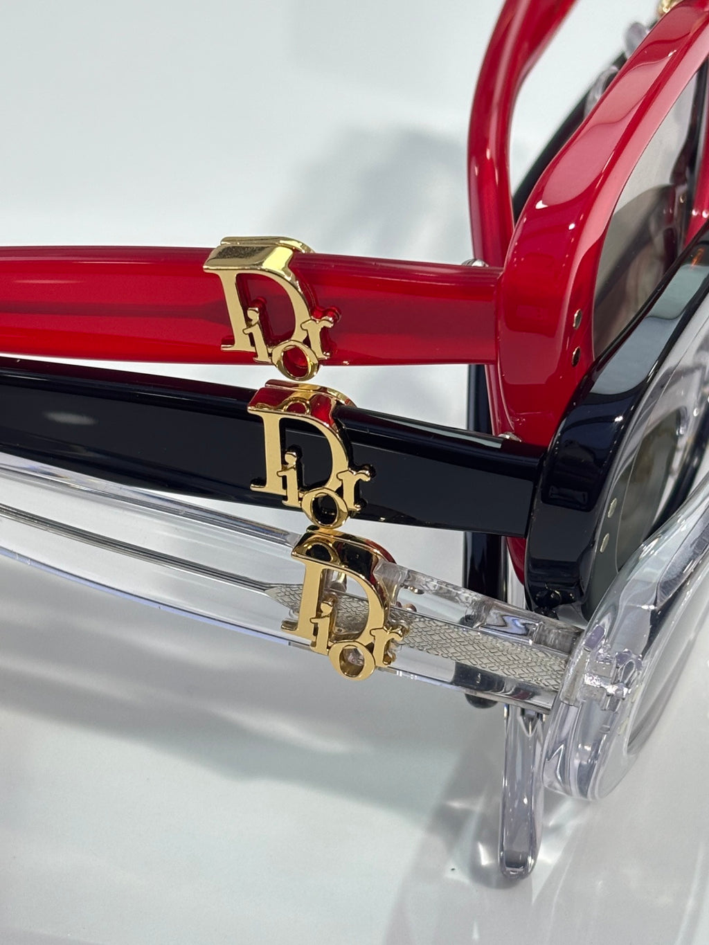 Dior logo on red and clear eyeglasses frame bar with gold-tone hardware