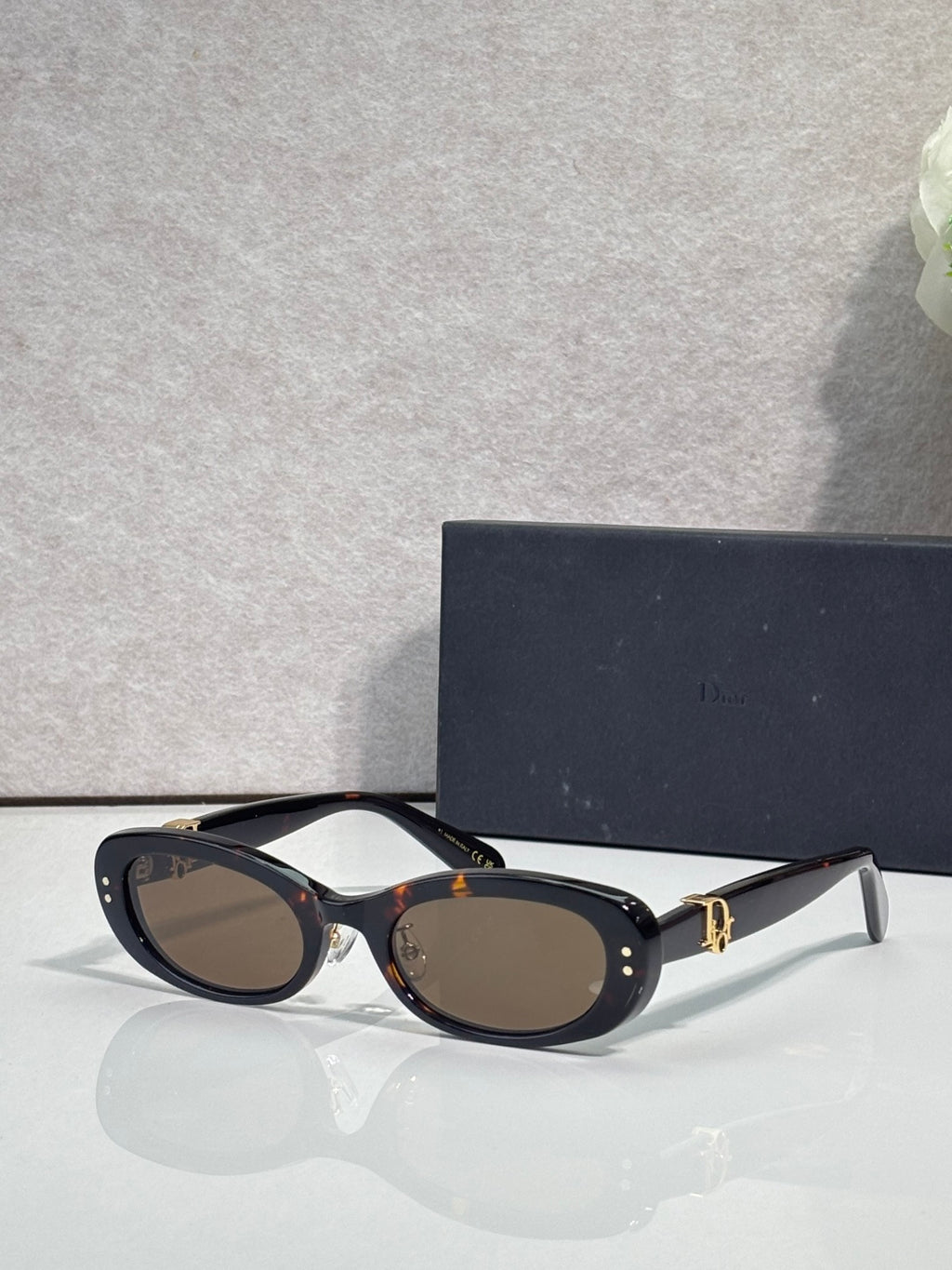 Black oval eyeglasses with dark lenses and silver-tone temples