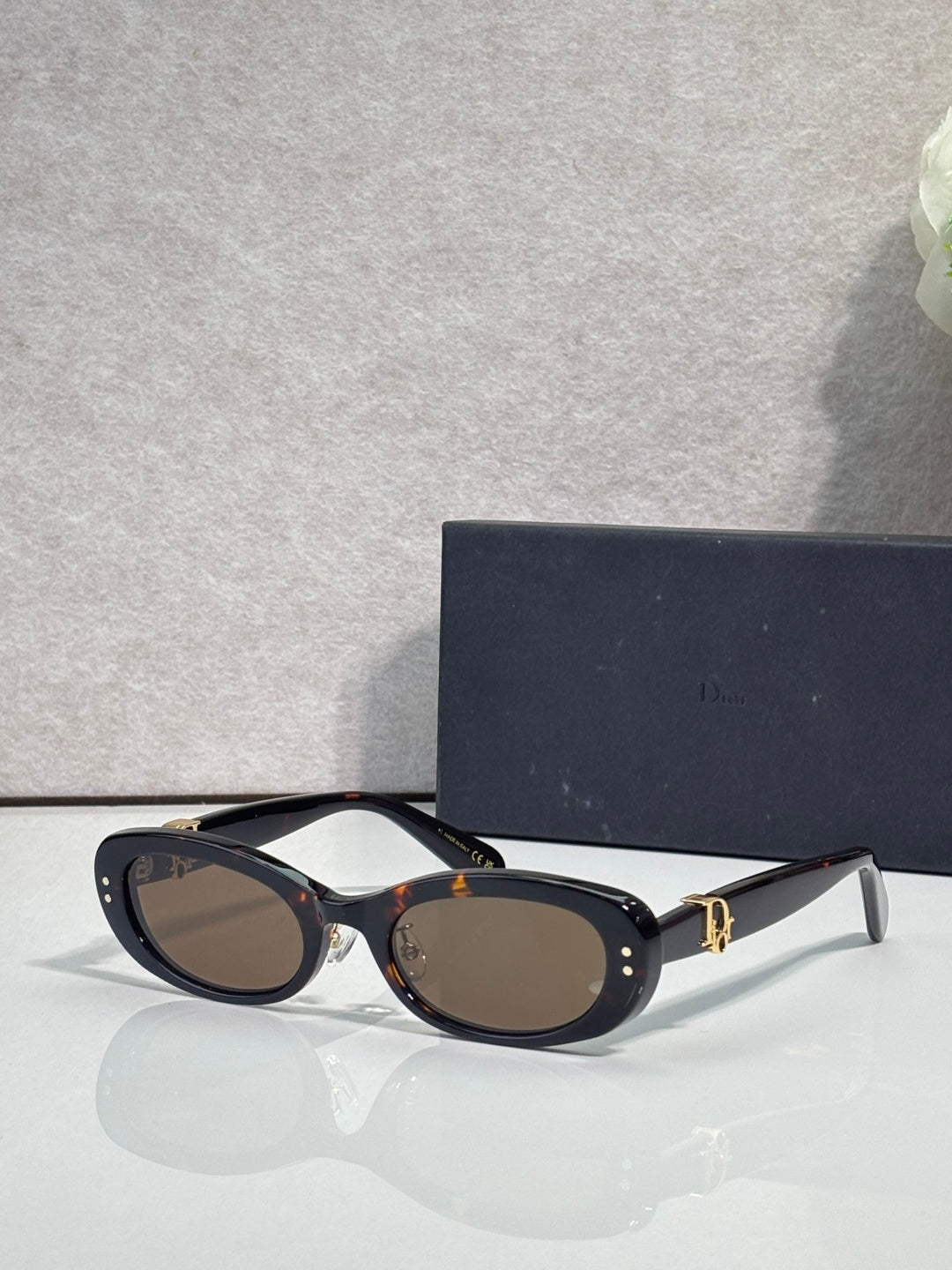 Black oval eyeglasses with dark lenses and silver-tone temples