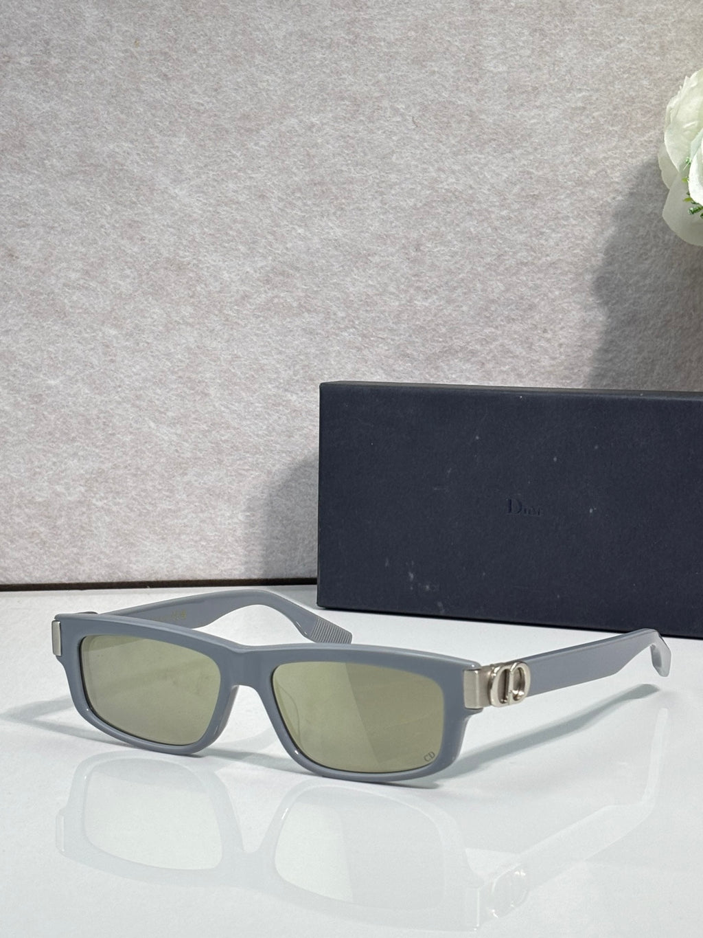 Dior black eyeglasses with green-tinted lenses and metal logo hinge