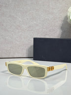 Dior light yellow cat-eye eyeglasses with green-tinted lenses and metal logo hinge