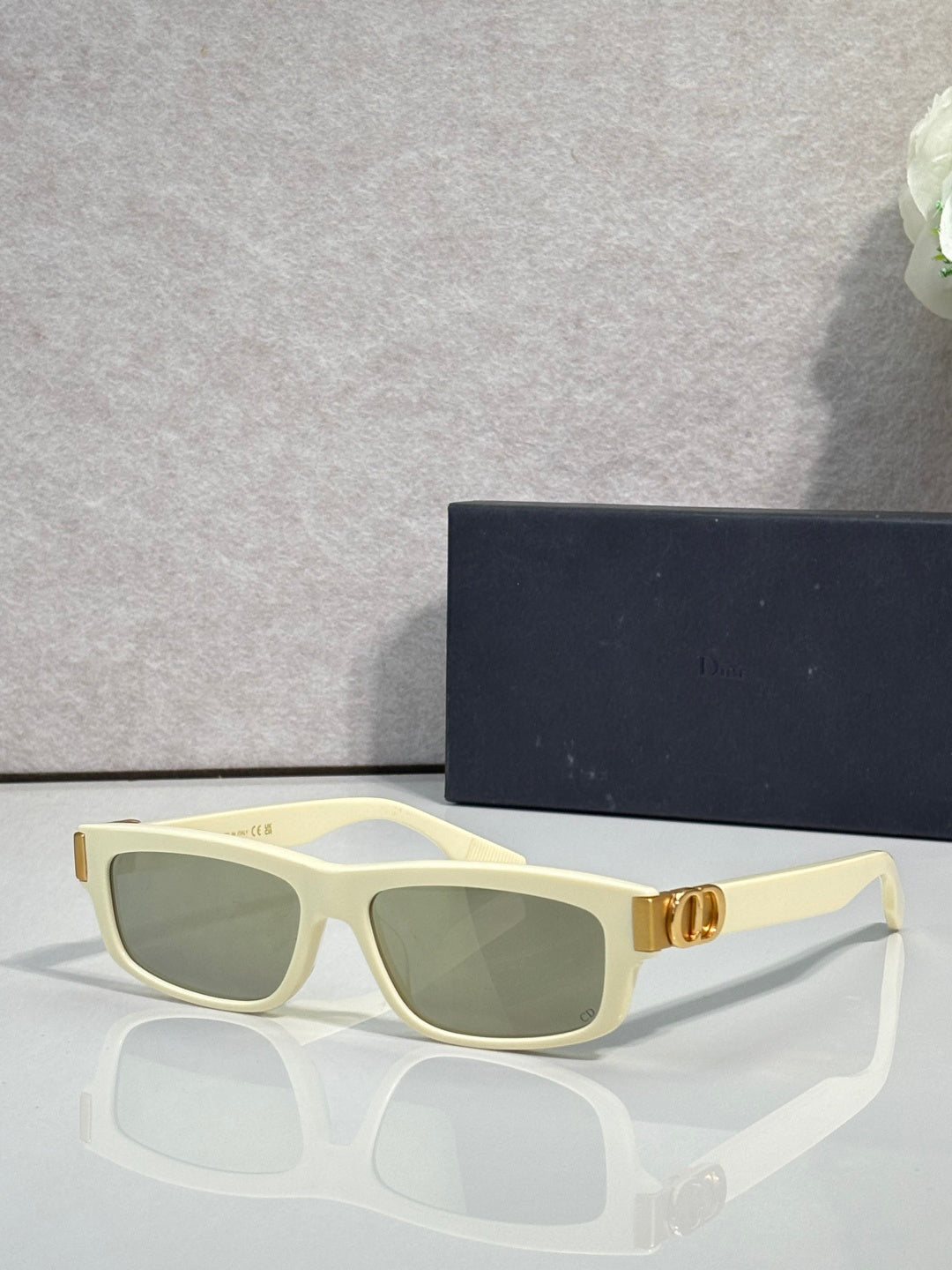 Dior light yellow cat-eye eyeglasses with green-tinted lenses and metal logo hinge