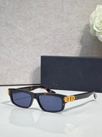 Dior black tortoiseshell acetate sunglasses with dark lenses and gold logo hinge