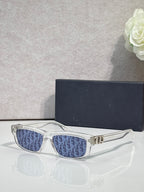 Dior glasses with white frame and blue patterned lenses, gold logo bridge.
