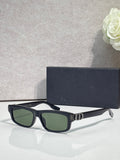 Dior glasses with dark frame and green tinted lenses, white temple tips.