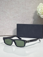 Dior glasses with dark frame and green tinted lenses, white temple tips.