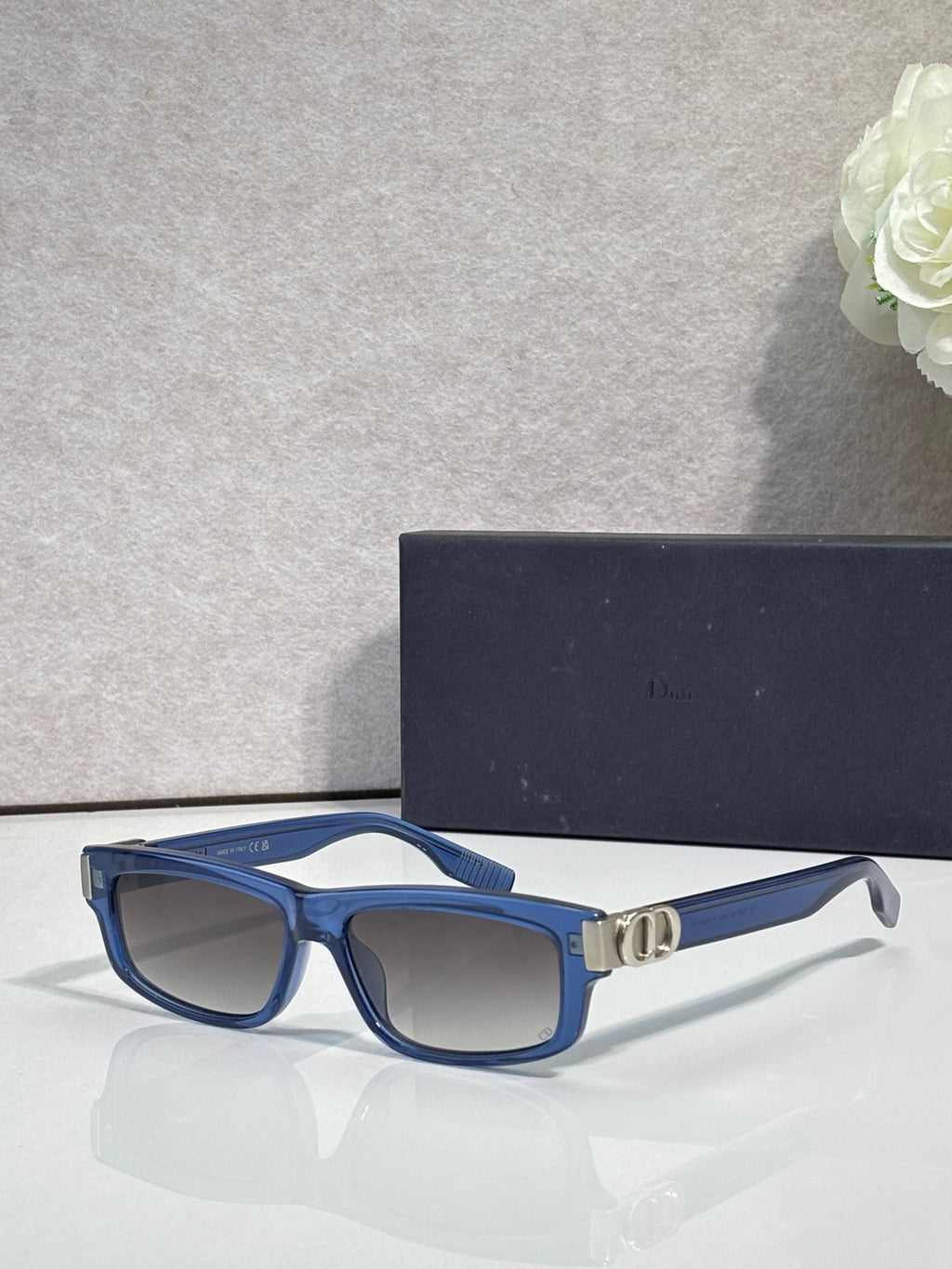 Dior glasses with blue frame, dark lenses, and gold bridge detail.