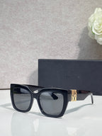 Dior glasses with dark blue frames, gold temple emblem, and tinted lenses