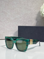 Dior glasses with green frames, gold temple emblem, and tinted lenses
