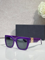 Dior glasses with purple frames, gold temple emblem, and tinted lenses