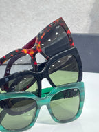 Stacked Dior glasses with green and tortoiseshell frames, gold temple lettering