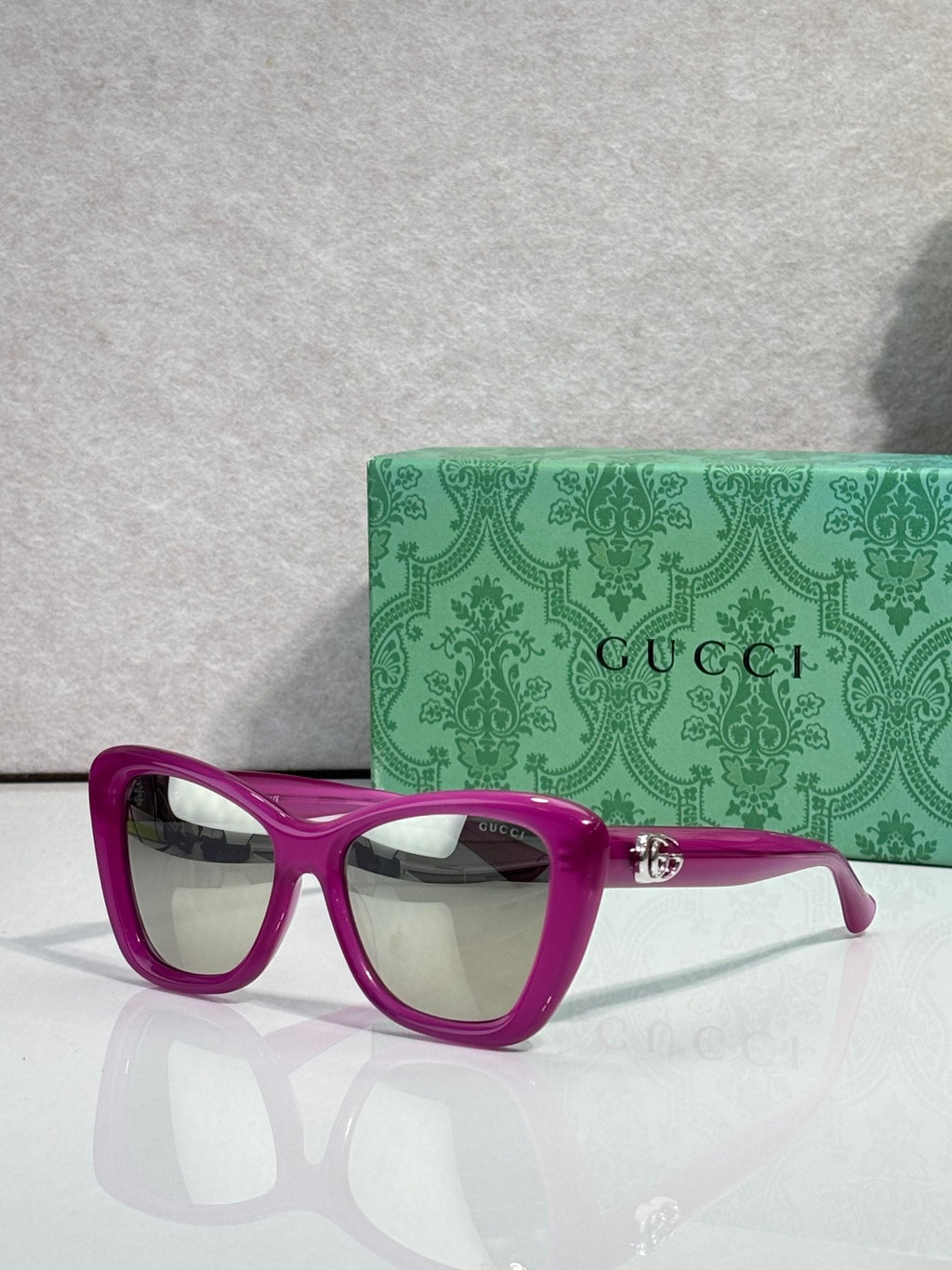 Designer eyeglasses with magenta frames and clear gradient lenses