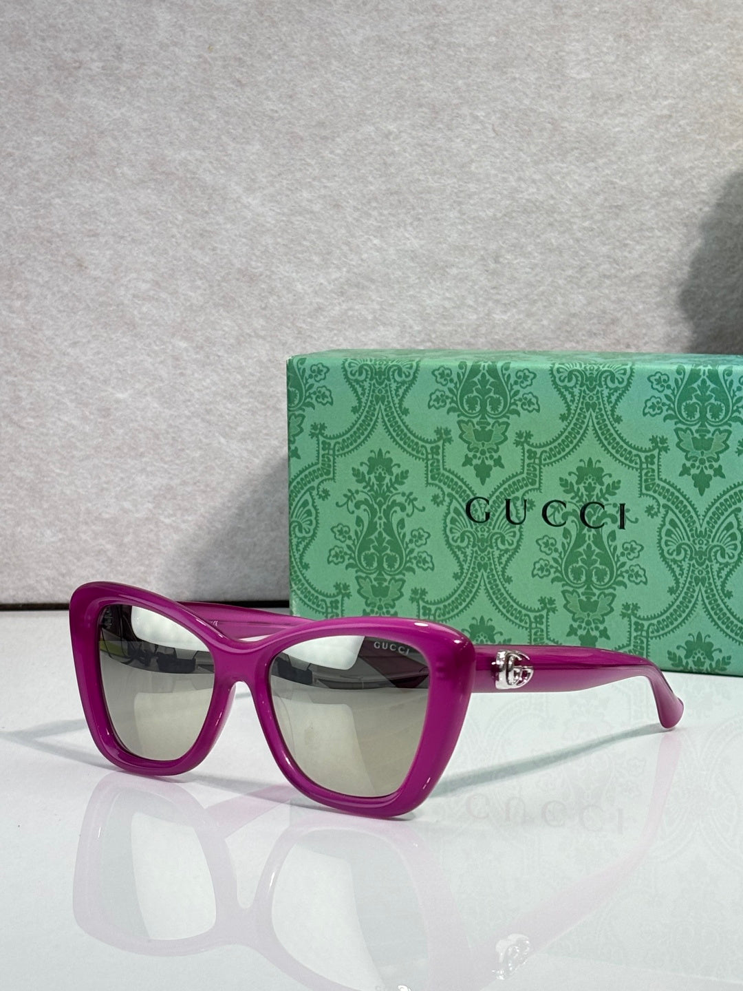 Designer eyeglasses with magenta frames and clear gradient lenses