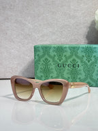 Designer eyeglasses with taupe-pink frames and pale tinted lenses