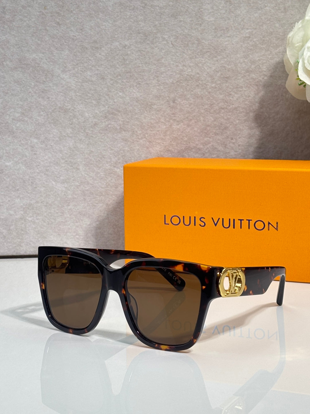 Sunglasses with dark tortoiseshell frame, brown-tinted lenses, and gold LV temple emblem