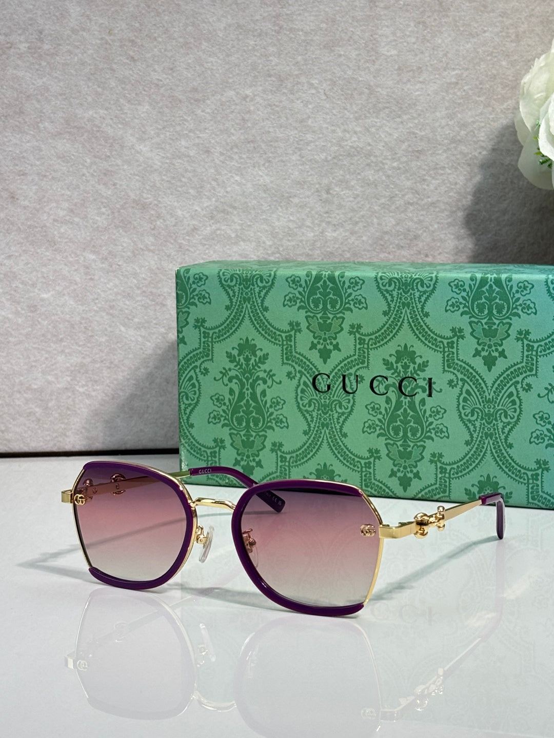 Gucci glasses with gradient purple tinted lenses, dark frame with gold hinge detail