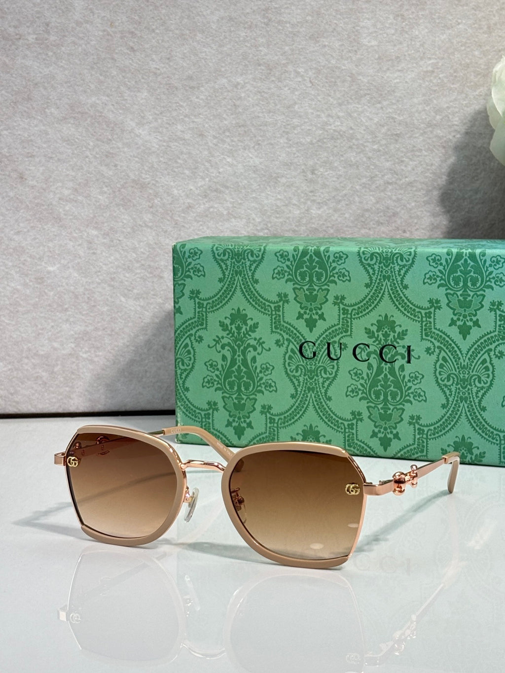 Gucci glasses with amber tinted lenses, gold metal frames and slim curved temples