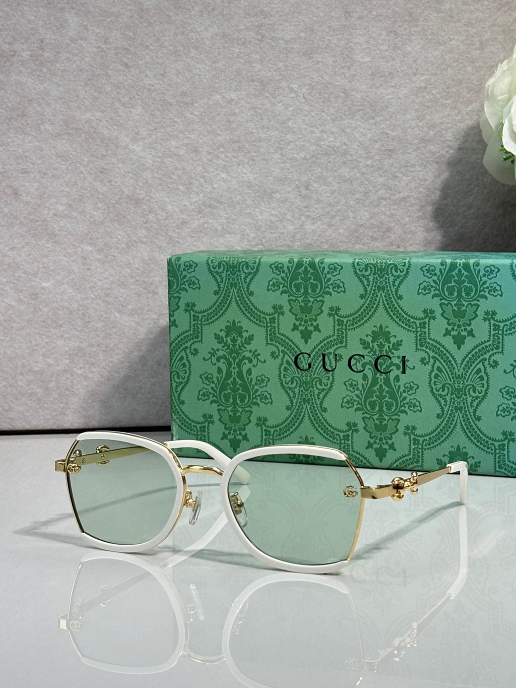 Gucci glasses with light green tinted lenses, thin gold metal frames and temples