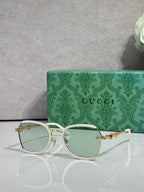 Gucci glasses with light green tinted lenses, thin gold metal frames and temples
