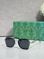 Gucci glasses with dark blue tinted lenses, black round frames and gold hinge hardware