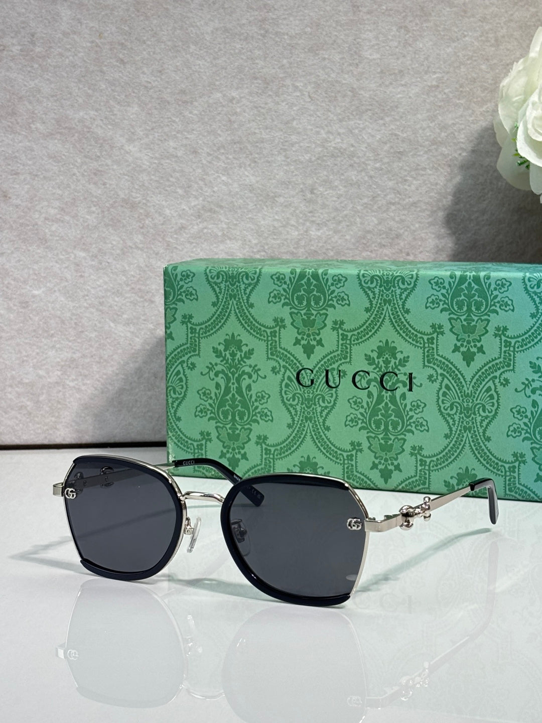 Gucci glasses with dark blue tinted lenses, black round frames and gold hinge hardware