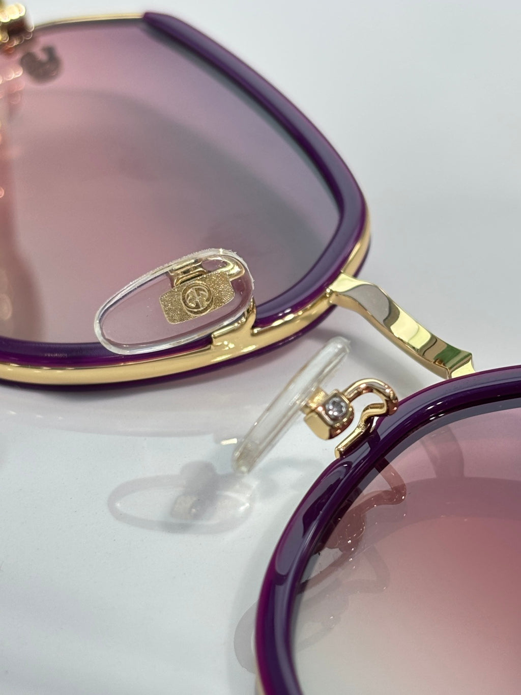 Gucci glasses close-up: purple temple with engraved metal loop and gold hinge hardware