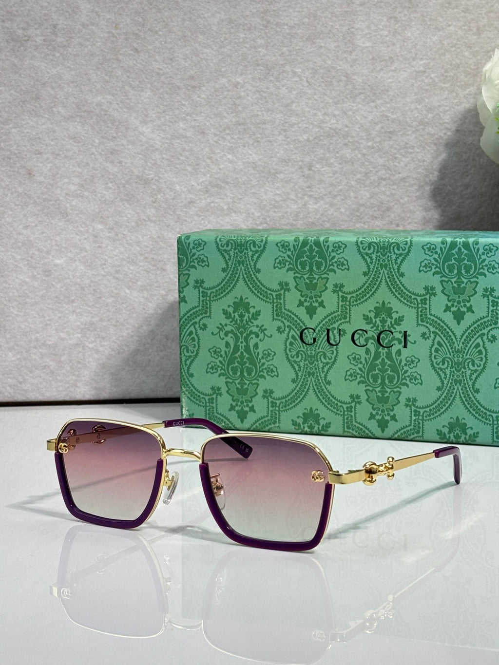 Gucci sunglasses with dark purple frames and warm gradient lenses, gold hardware