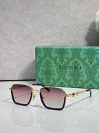 Gucci sunglasses with dark purple frames and warm gradient lenses, gold hardware