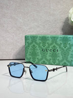 Gucci sunglasses with black frames and light blue gradient lenses, gold accents