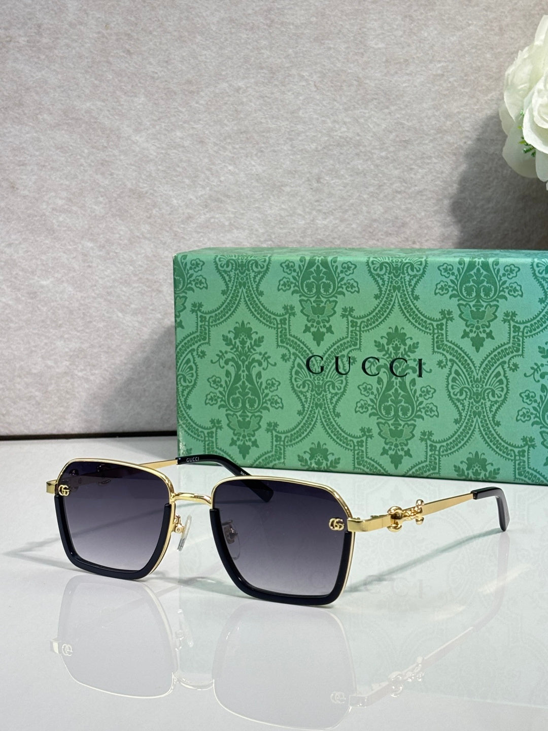 Gucci sunglasses with black frames, dark lenses, and gold bridge hardware