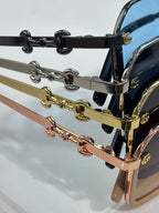 Gucci sunglasses with chain temple detail in black, gold, and rose tones