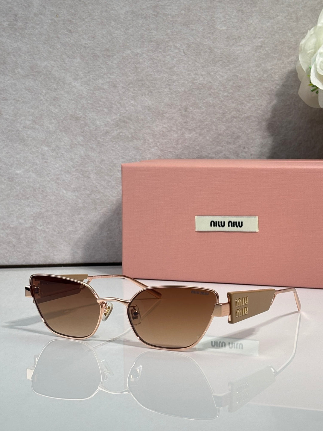 MiuMiu sunglasses with gold frame and brown-tinted lenses