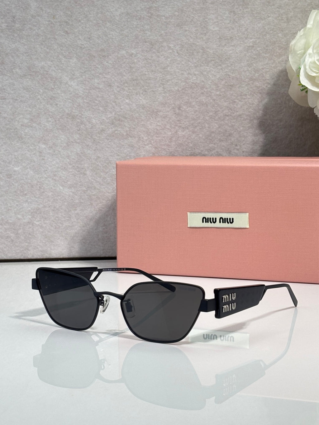 MiuMiu sunglasses with black frame and dark lenses
