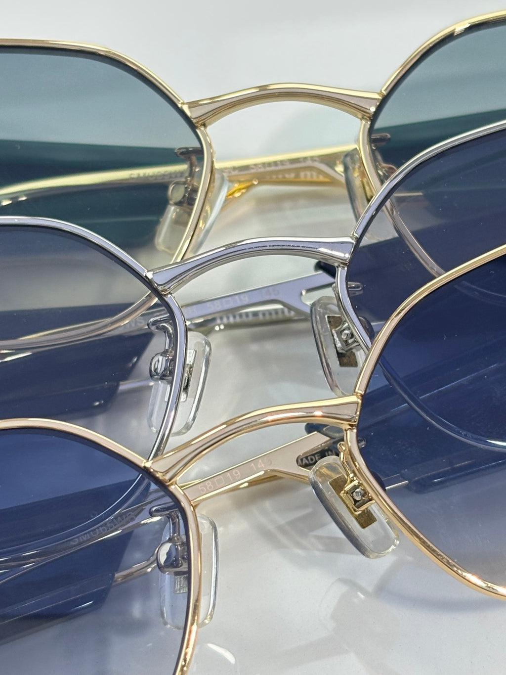 MiuMiu sunglasses close-up with blue lenses and gold frames
