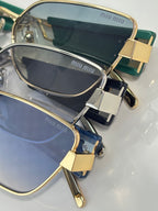 MiuMiu sunglasses close-up with gold frame and navy lenses