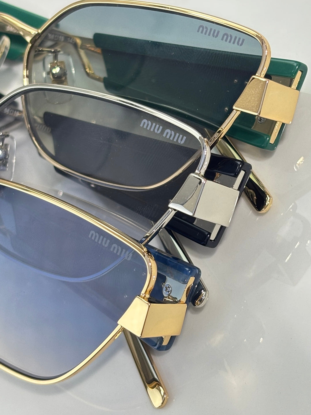 MiuMiu sunglasses close-up with gold frame and navy lenses