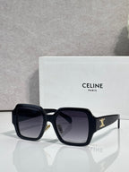 Black rectangular sunglasses at an angle with dark lenses and gold logo on the temple
