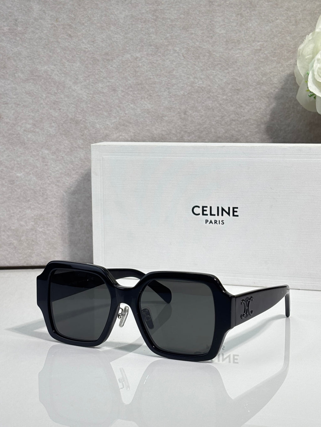 Black rectangular sunglasses with dark lenses and gold logo on the side temple