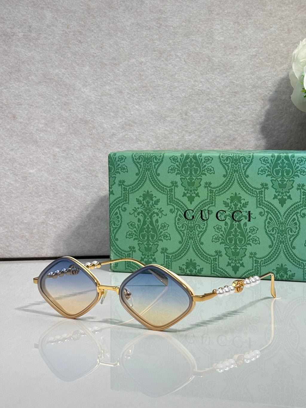 Gucci sunglasses with light brown lenses and gold metal frames, arched square style