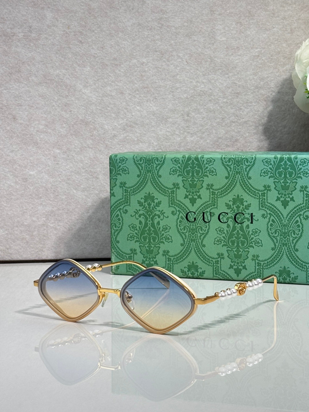 Gucci sunglasses with light brown lenses and gold metal frames, arched square style