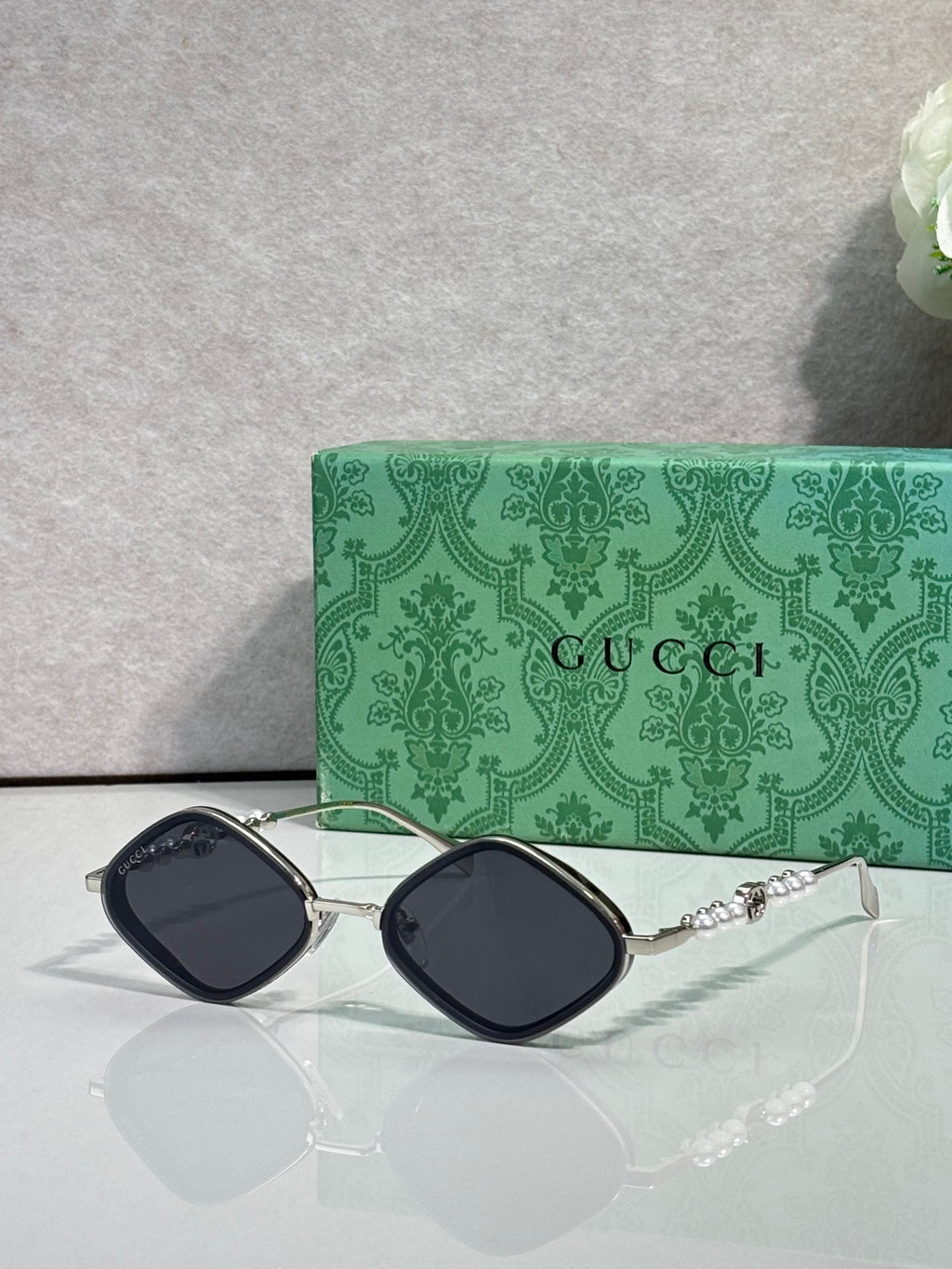 Gucci sunglasses with dark lenses and silver metal frames, arched square style